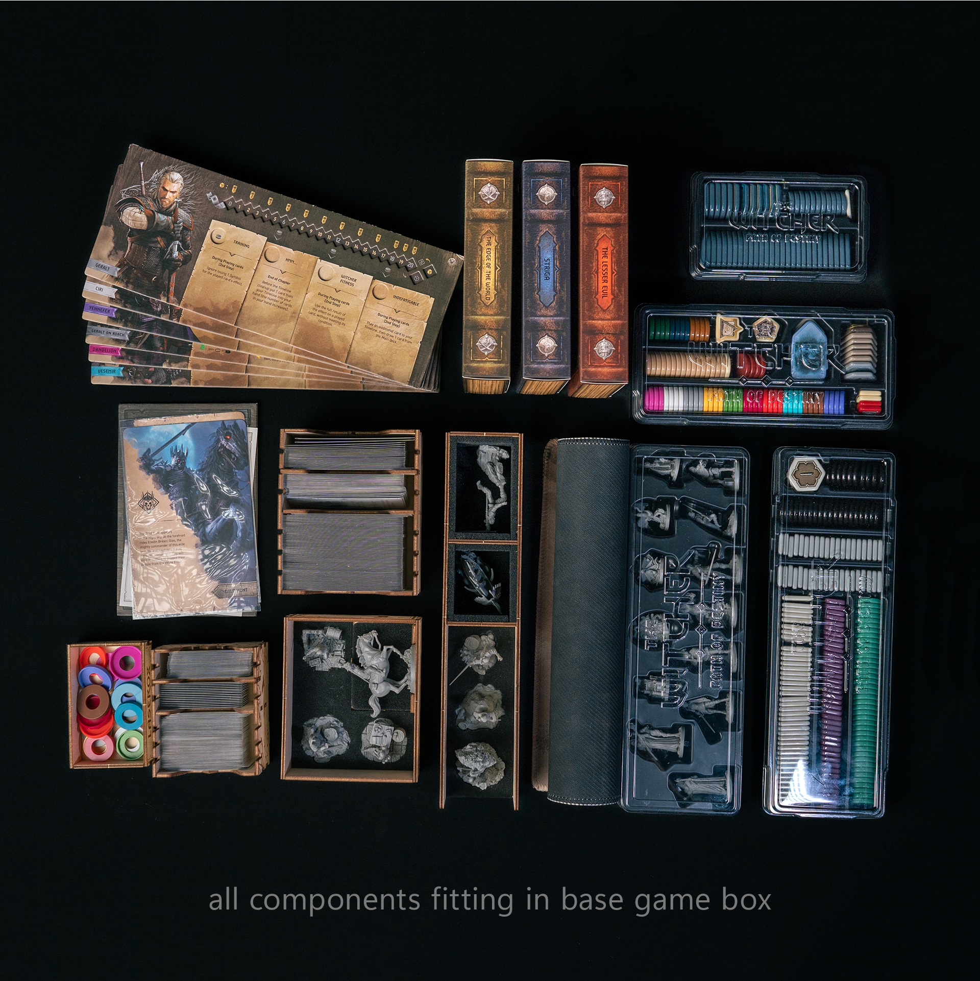 Collection of game components including cards, books, and miniatures on a black background